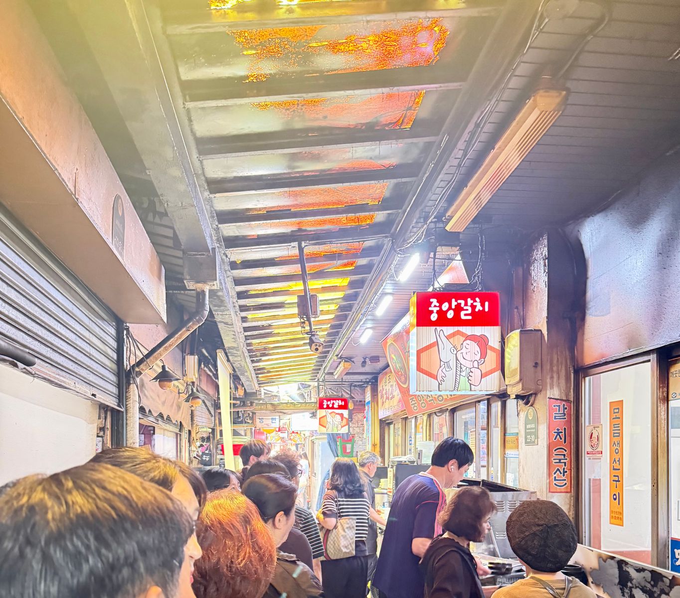 Diners waiting outside Jungang Galchi in the covered Namdaemun Hairtail Alley