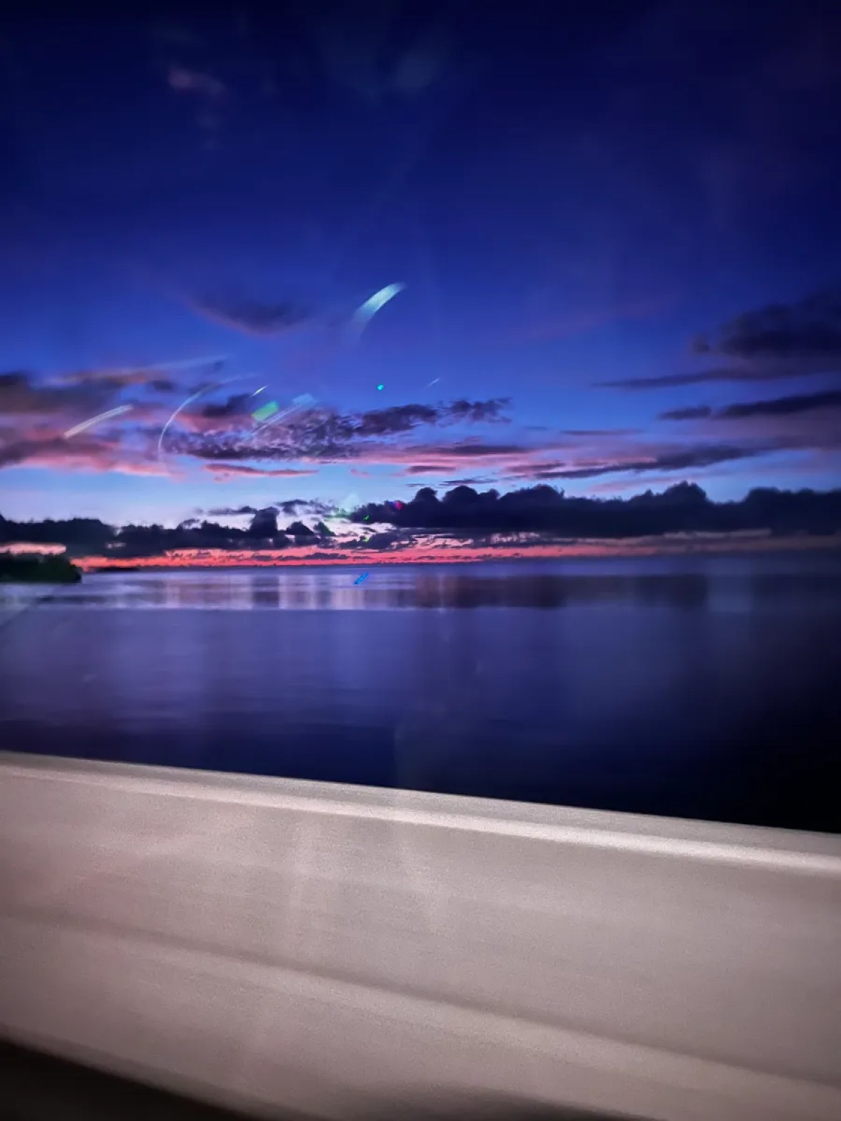 Purple evening sky over the sea in Palau, photographed through a vehicle window
