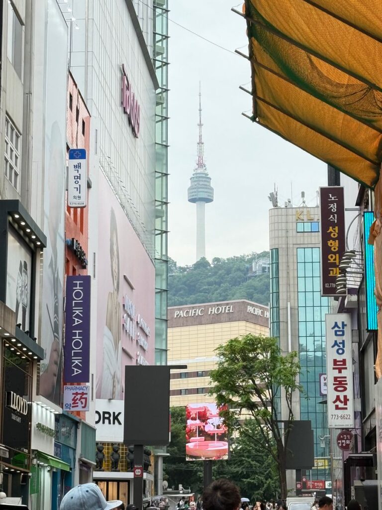 Myeongdong shopping street with N Seoul Tower visible between buildings