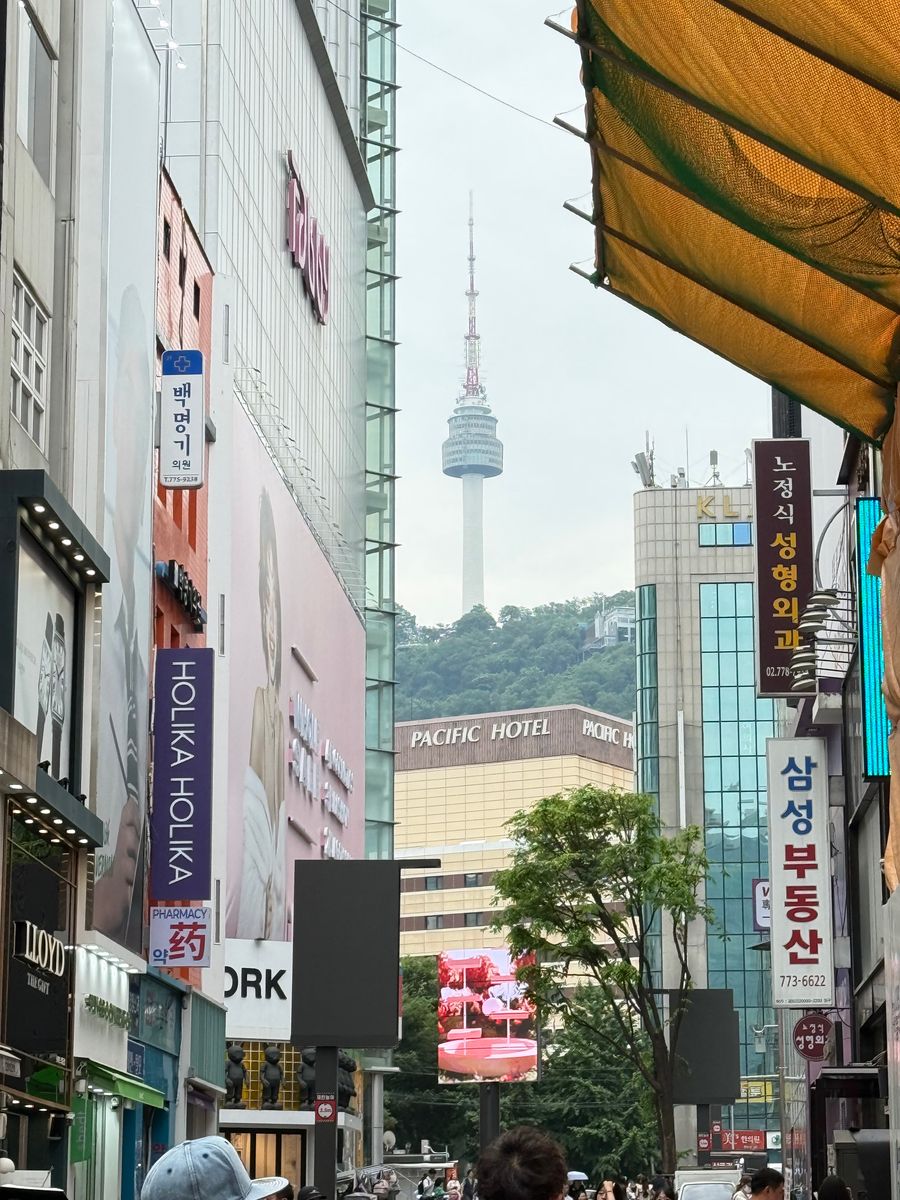 Myeongdong shopping street with N Seoul Tower visible between buildings